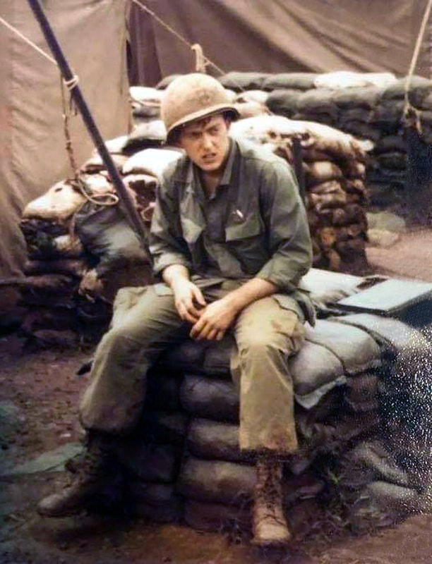 Richard Colburn getting off his seat in the most common seat in Vietnam, a pile of sandbags.